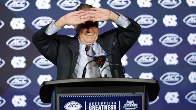 UNC football coach Bill Belichick shields his eyes as he speaks to the media at the 2025 ACC Kickoff in Charlotte, N.C., Thursday, July 24, 2025. (Photo by Nell Redmond/ACC)