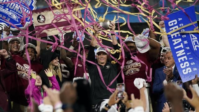 Florida State coach Mike Norvell lifts the trophy after the team's win over Louisville in the Atlantic Coast Conference championship NCAA college football game Saturday, Dec. 2, 2023, in Charlotte, N.C. (AP Photo/Erik Verduzco)