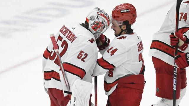 Carolina Hurricanes goalie Pyotr Kochetkov (52) celebrates with teammate Seth Jarvis (24) after defeating the Chicago Blackhawks in an NHL hockey game Sunday, April 14, 2024, in Chicago. (AP Photo/Paul Beaty)
