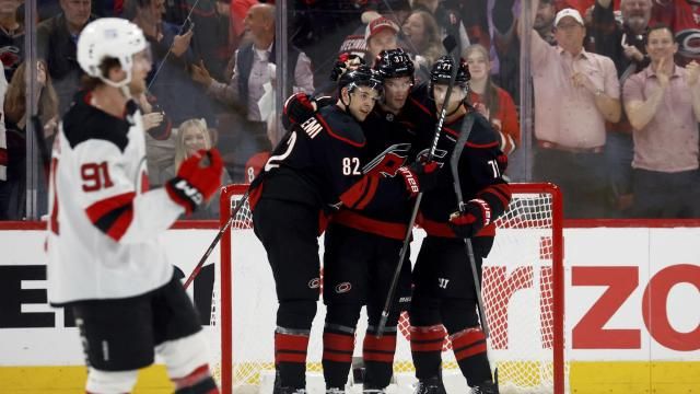 Carolina Hurricanes' Andrei Svechnikov, center, celebrates his goal with Jesperi Kotkaniemi (82) and Taylor Hall (71) during the third period of Game 1 of an NHL hockey Stanley Cup first-round playoff series against the New Jersey Devils in Raleigh, N.C., Sunday, April 20, 2025. (AP Photo/Karl DeBlaker)