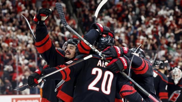 Carolina Hurricanes' Seth Jarvis, left, salutes the crowd from the celebration of Sebastian Aho's game-winning goal during the second overtime period of Game 5 of an NHL hockey Stanley Cup first-round playoff series against the New Jersey Devils in Raleigh, N.C., Tuesday, April 29, 2025. (AP Photo/Karl DeBlaker)