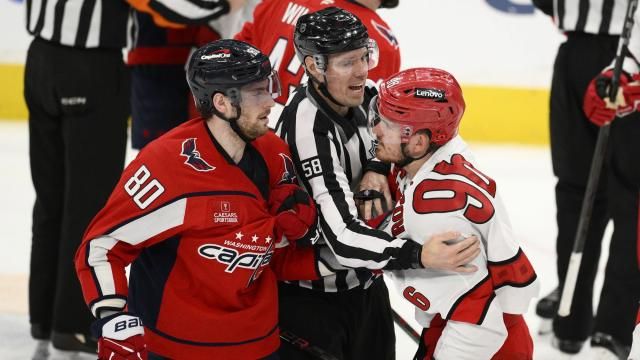 Washington Capitals left wing Pierre-Luc Dubois (80) and Carolina Hurricanes center Jack Roslovic (96) are separated by linesman Ryan Gibbons (58) in the third period of Game 2 of a second-round NHL hockey playoff series Thursday, May 8, 2025, in Washington. (AP Photo/Nick Wass)