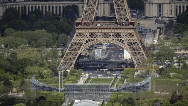 Stands are under construction on the Champ-de-Mars, foreground, with the Eiffel Tower in background, Monday, April 15, 2024 in Paris. The Champ-de-Mars will host the Beach Volleyball and Blind Football at the Paris 2024 Olympic and Paralympic Games. (AP Photo/Aurelien Morissard)