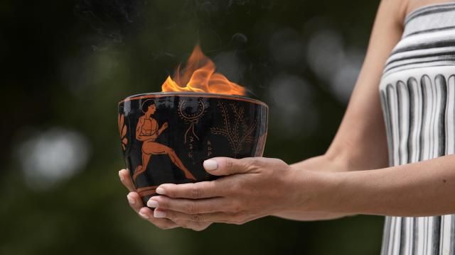 A performer holds a ceramic pot with the flame during the official ceremony of the flame lighting for the Paris Olympics, at the Ancient Olympia site, Greece, Tuesday, April 16, 2024. The flame will be carried through Greece for 11 days before being handed over to Paris organizers on April 26. (AP Photo/Thanassis Stavrakis)